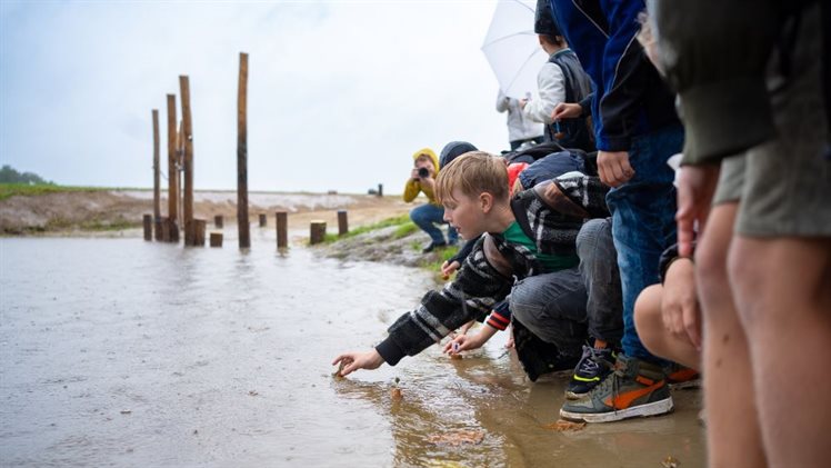 Kinderen laten zelfgemaakte bootjes te water